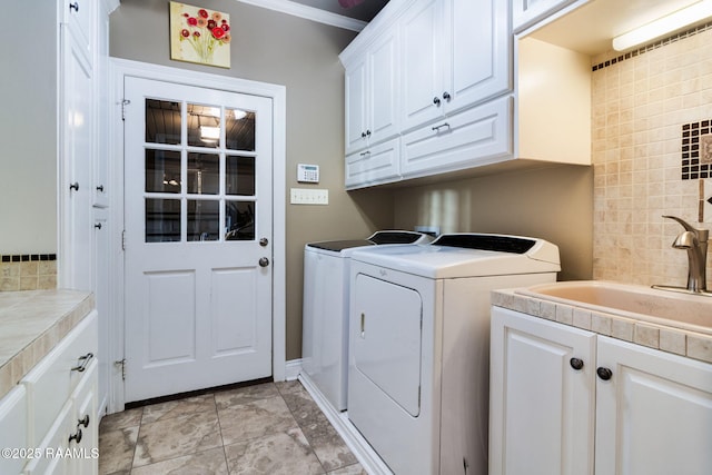 laundry area with cabinets, sink, and washer and dryer