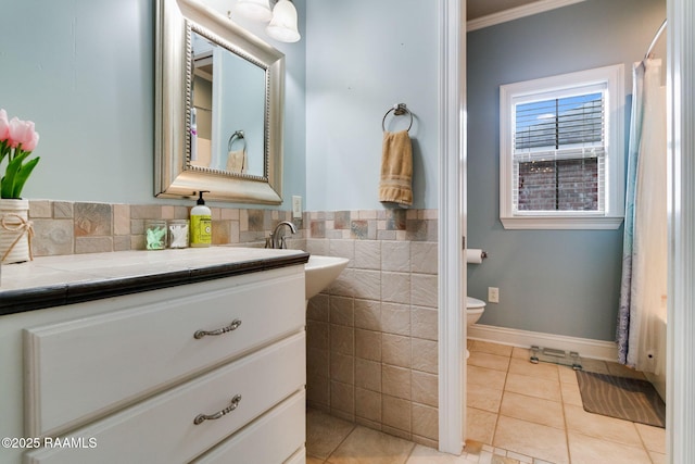 bathroom with tile walls, tile patterned flooring, vanity, toilet, and crown molding