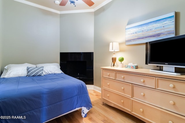 bedroom featuring crown molding, ceiling fan, and light wood-type flooring