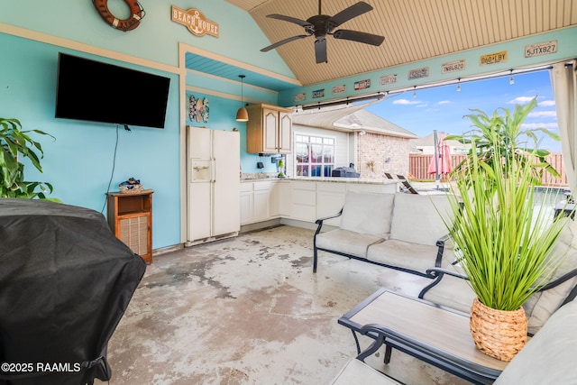 kitchen featuring lofted ceiling, ceiling fan, white fridge with ice dispenser, and white cabinets