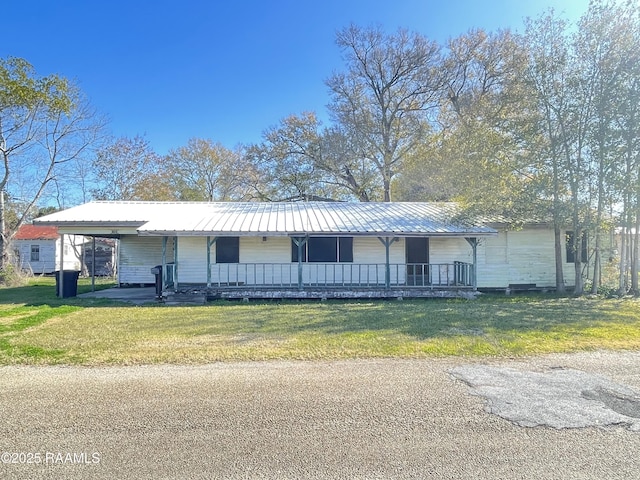 single story home with a front lawn, a carport, and covered porch