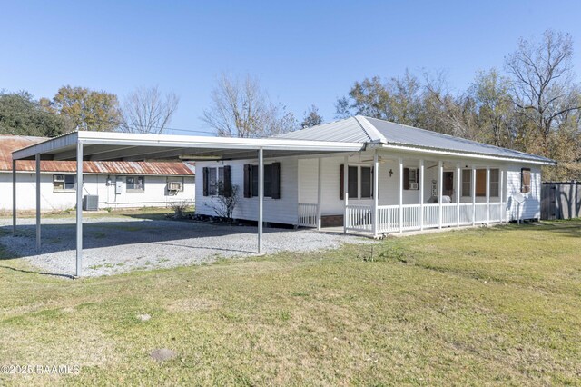 view of front facade with a front yard, a porch, a carport, and central AC unit