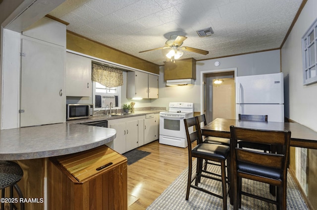 kitchen featuring white appliances, sink, ornamental molding, light wood-type flooring, and ceiling fan