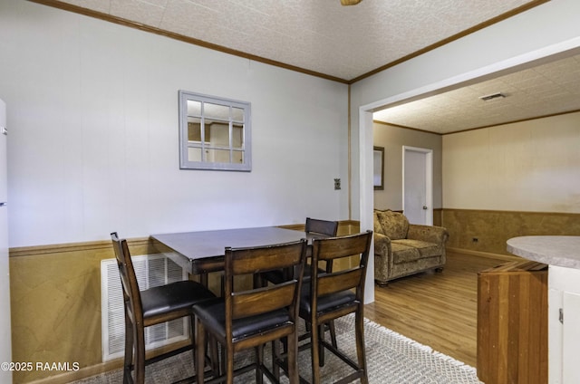 dining room featuring ornamental molding and hardwood / wood-style floors