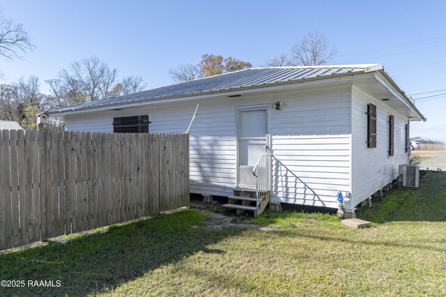 back of property featuring a yard and central air condition unit