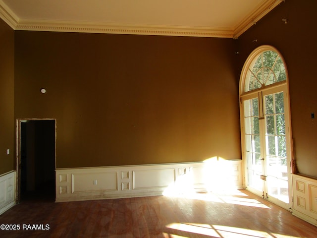 spare room featuring crown molding, light hardwood / wood-style floors, and french doors