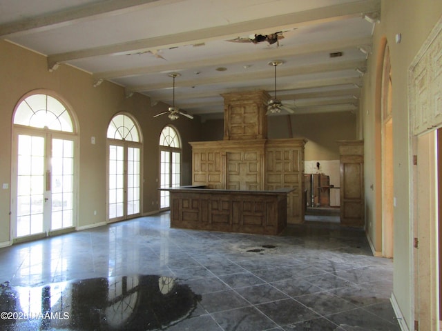 interior space featuring beam ceiling, french doors, hanging light fixtures, and a center island