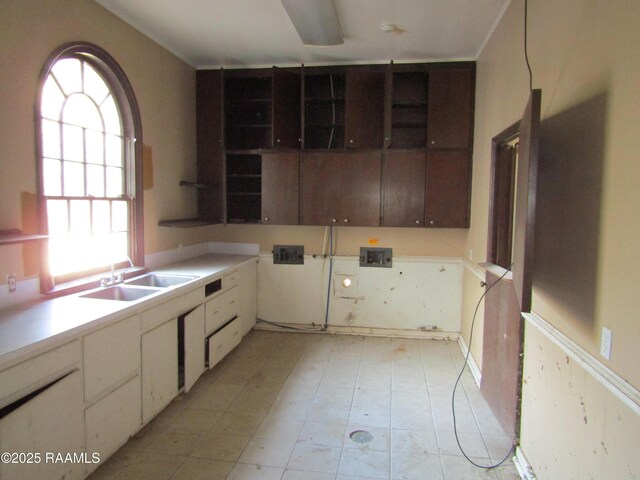 kitchen with plenty of natural light, white cabinets, and sink