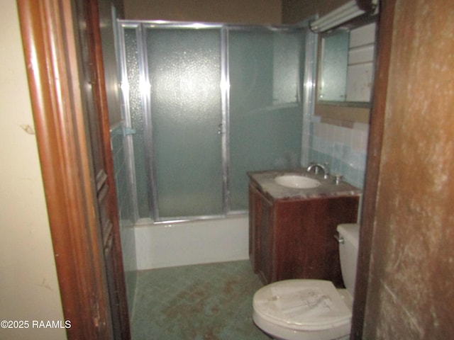 full bathroom featuring bath / shower combo with glass door, toilet, and vanity