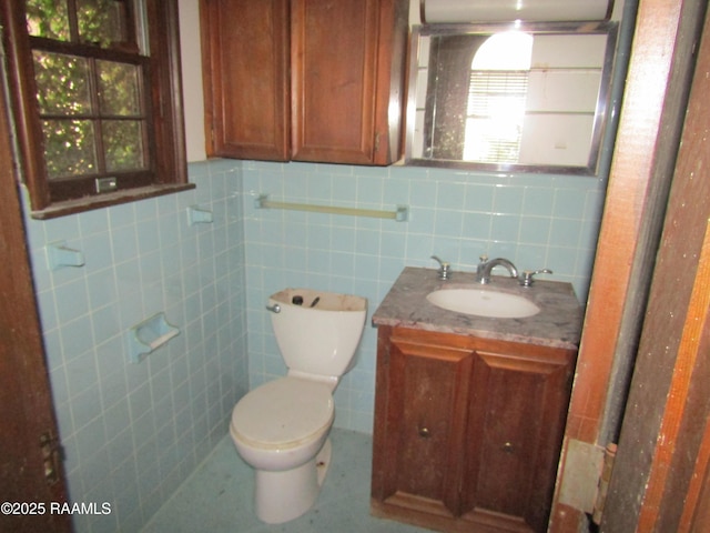 bathroom featuring toilet, tile walls, tile patterned floors, and vanity