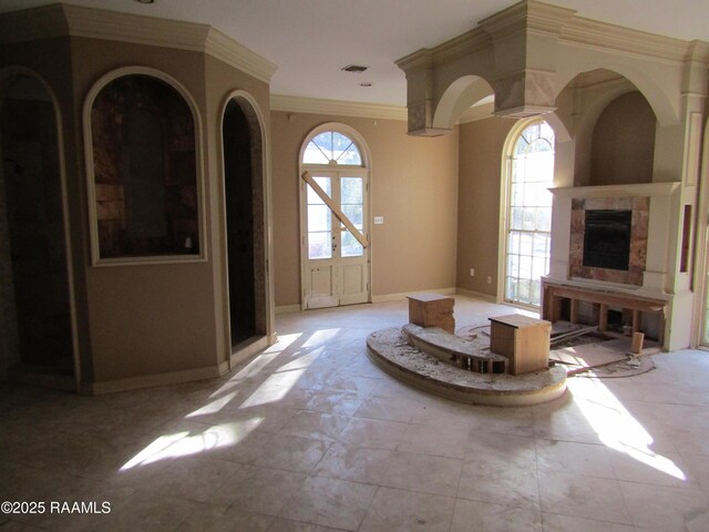 unfurnished living room featuring crown molding