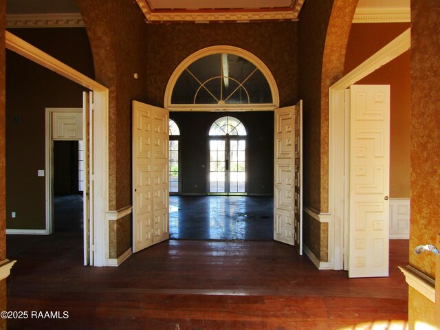 entrance foyer with wood-type flooring, arched walkways, and a towering ceiling