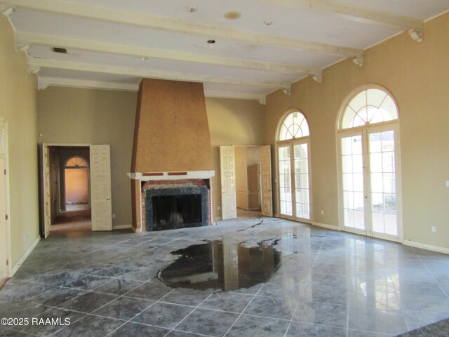 unfurnished living room featuring baseboards, a fireplace, and beam ceiling
