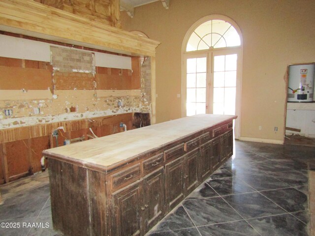 kitchen featuring dark brown cabinetry, butcher block counters, and water heater