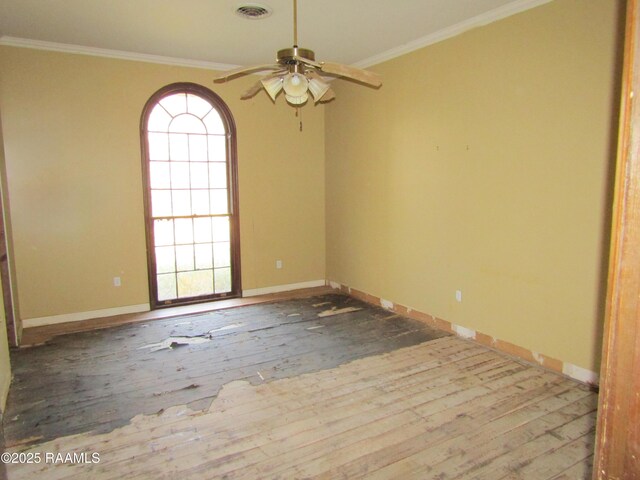 empty room with hardwood / wood-style floors, a ceiling fan, baseboards, visible vents, and ornamental molding