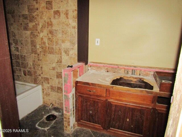 bathroom featuring tile patterned floors, a bathing tub, and tile walls