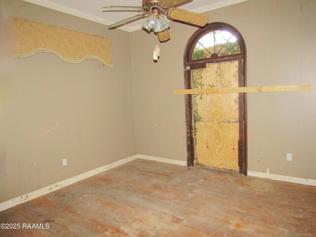 unfurnished room with a ceiling fan, baseboards, ornamental molding, and wood finished floors