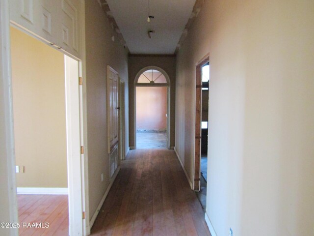 corridor with baseboards and light wood-type flooring
