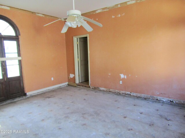 empty room featuring baseboards and a ceiling fan