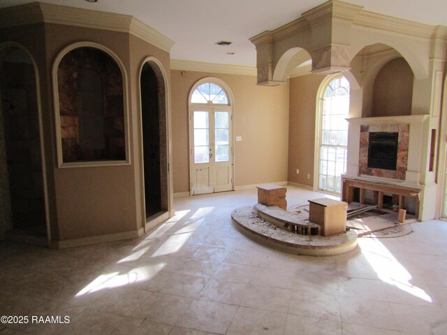 living area featuring crown molding, baseboards, and a fireplace