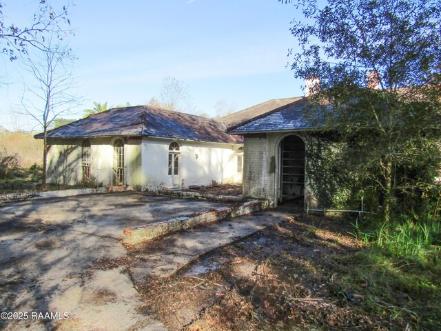 view of front of house featuring a chimney and stucco siding