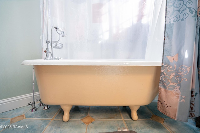 bathroom featuring tile patterned flooring and a freestanding bath