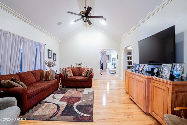 living area featuring light wood finished floors, ceiling fan, arched walkways, and crown molding