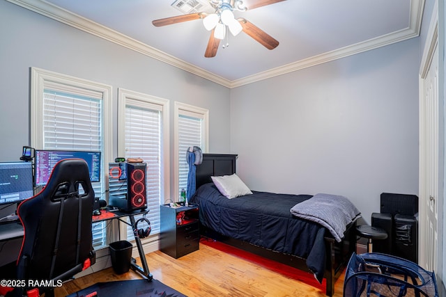 bedroom featuring ceiling fan, wood finished floors, and crown molding