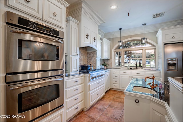 kitchen with stainless steel appliances, white cabinets, and visible vents