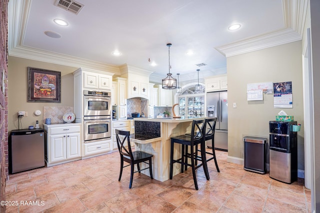 kitchen featuring pendant lighting, light countertops, visible vents, appliances with stainless steel finishes, and white cabinetry