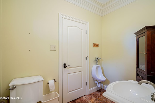 bathroom with crown molding, baseboards, and a sink