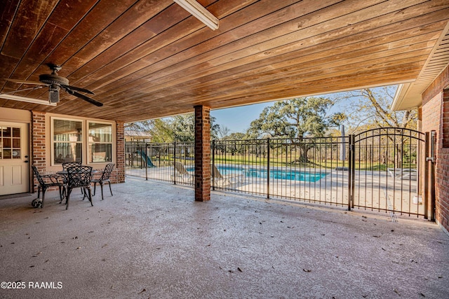 view of patio / terrace with a fenced in pool, fence, and a ceiling fan