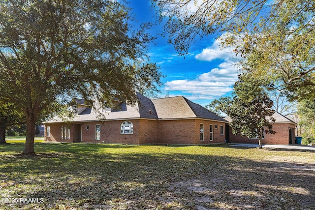 view of home's exterior with brick siding and a lawn