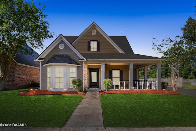 view of front of property with covered porch, a front yard, and ceiling fan