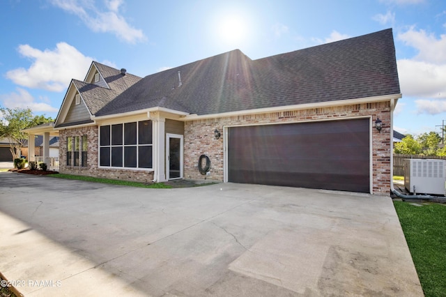 view of front of house with central AC unit and a garage