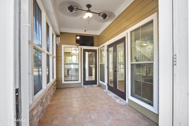 unfurnished sunroom with ceiling fan and french doors