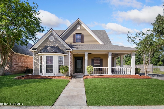 view of front of home with a front lawn, a porch, and central AC