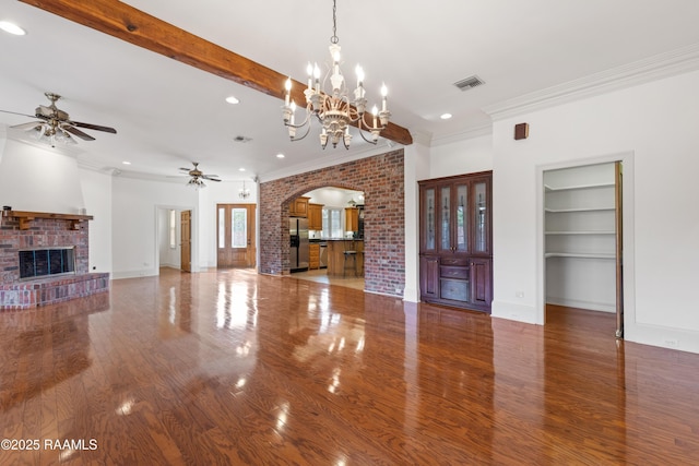 unfurnished living room with ceiling fan, wood-type flooring, beam ceiling, and a brick fireplace