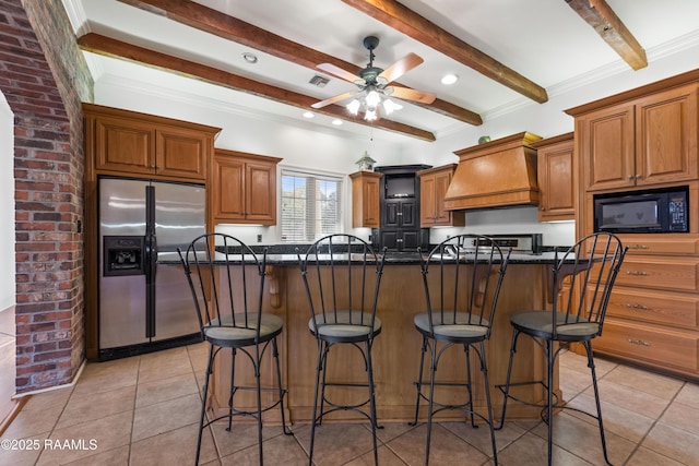 kitchen featuring black microwave, premium range hood, a kitchen breakfast bar, and stainless steel fridge with ice dispenser