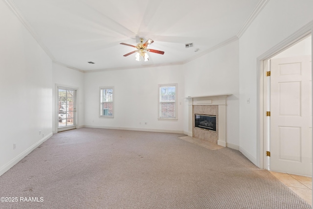 unfurnished living room featuring ornamental molding, a healthy amount of sunlight, a premium fireplace, and light carpet