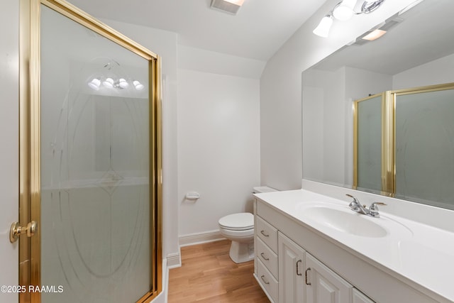 bathroom with wood-type flooring, toilet, an enclosed shower, and vanity