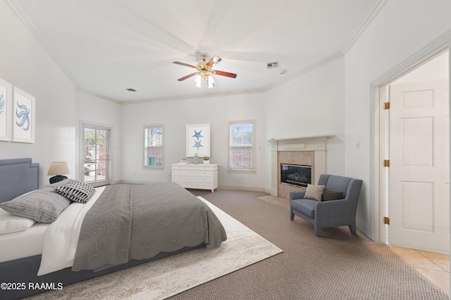 bedroom with ceiling fan, ornamental molding, a fireplace, and light colored carpet