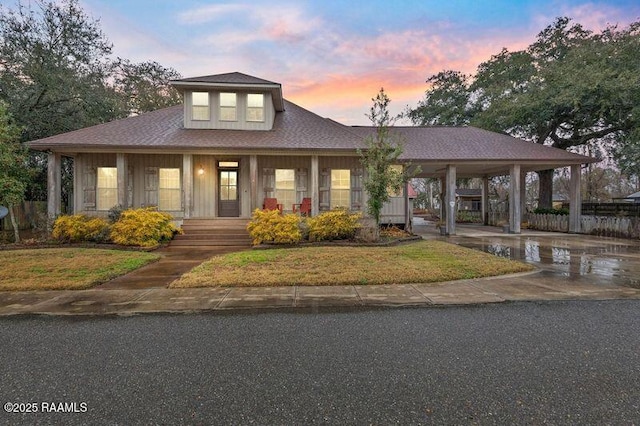 view of front of property with a carport, a porch, and a lawn