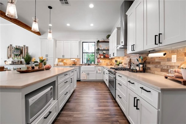 kitchen with stainless steel appliances, light countertops, open shelves, and visible vents