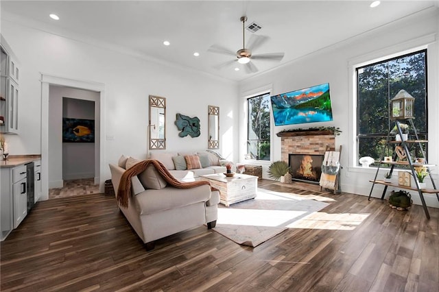 living room with ceiling fan, recessed lighting, visible vents, a lit fireplace, and dark wood finished floors