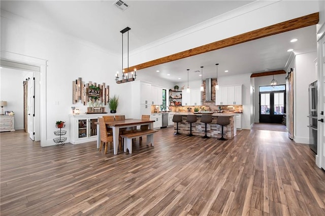 dining area with visible vents, dark wood-style floors, an inviting chandelier, crown molding, and recessed lighting