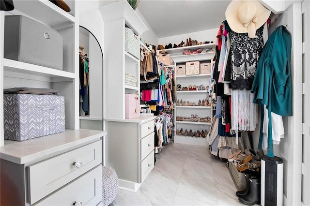 walk in closet with marble finish floor