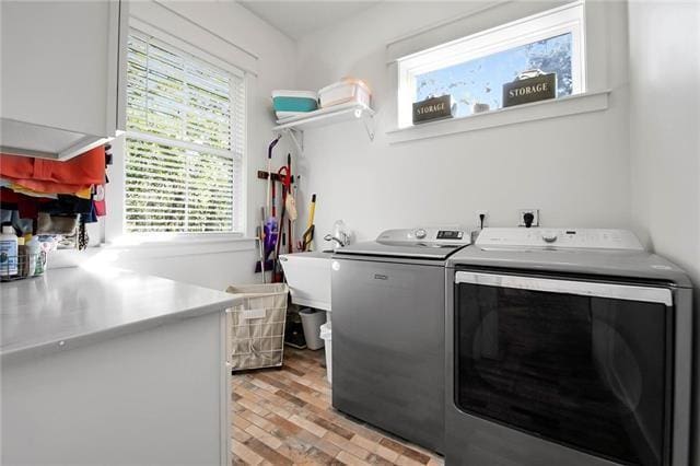 laundry room with laundry area, light wood finished floors, and washing machine and clothes dryer