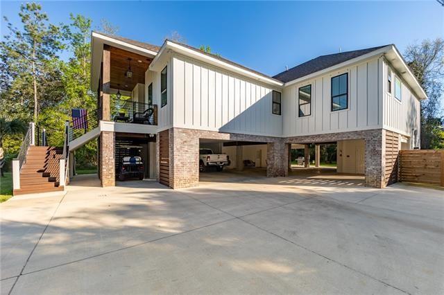 view of front of property featuring a carport, stairway, board and batten siding, and driveway