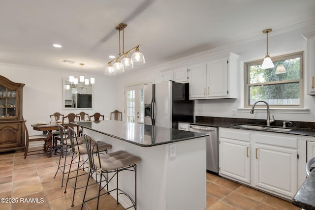 kitchen featuring stainless steel appliances, a center island, white cabinets, and sink